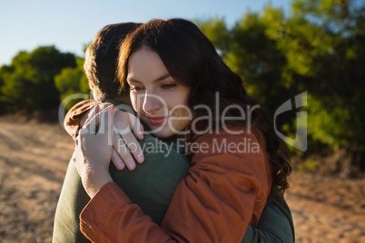 Couple embracing on field