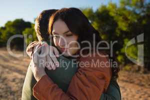 Couple embracing on field