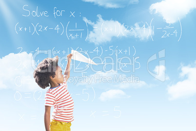 Composite image of boy playing with paper airplane