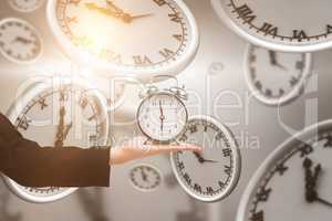 Composite image of hand holding alarm clock