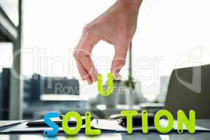 Composite image of cropped image of businessman arranging solution word
