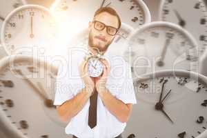 Composite image of geeky businessman holding alarm clock