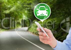 Hand holding phone with car icon on road