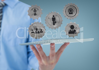 Business man interacting with people in cogs graphics against blue background