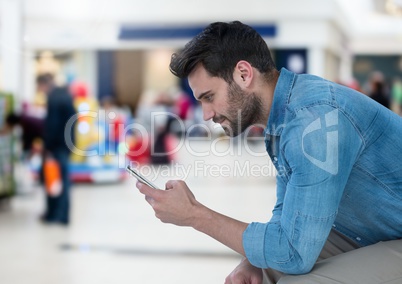 Man holding phone in mall shopping center