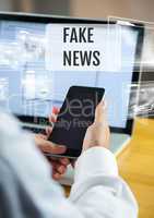 Holding phone with Fake news text and interface