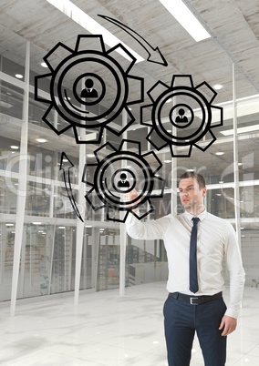 Business man interacting with people in cogs graphics against office background