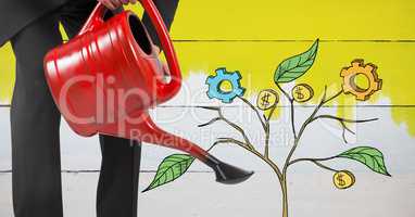 Holding watering can and Drawing of Business graphics on plant branches on wall
