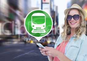 Woman holding phone with train icon in city