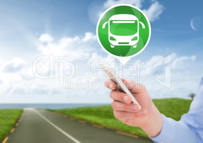 Hand holding phone with bus icon on road