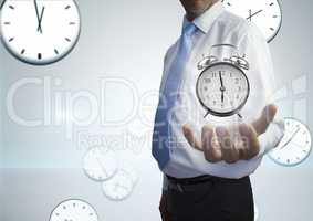 Business man holding a clock against background with clocks