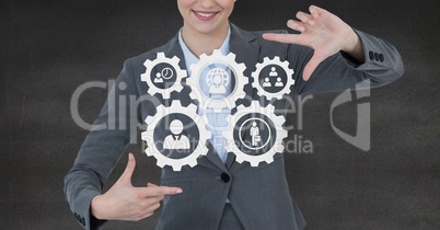 Business woman interacting with people in cogs graphics against grey background