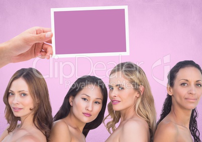 Hand holding card with womens' heads and pink background