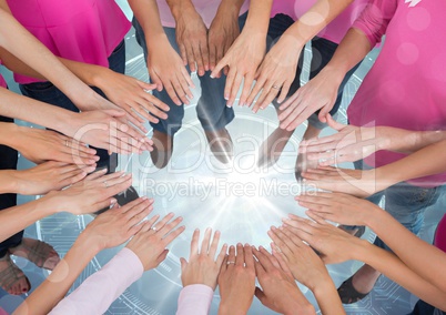 Hands together in circle over bright portal light with pink t-shirts