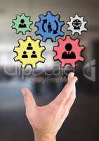 Hand interacting with people in cogs graphics against office background
