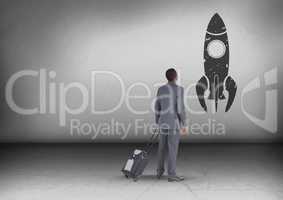 Businessman with travel bag looking up with rocket icon