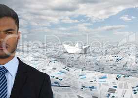 Businessman in sea of documents under sky clouds and paper boat