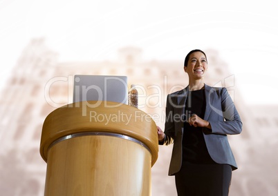 Businesswoman on podium speaking at conference with buildings