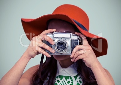 Close up of millennial woman with camera in Summer hat against light grey background