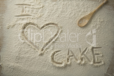 High angle view of i love cake text on flour