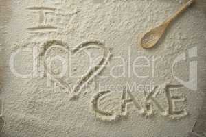 High angle view of i love cake text on flour