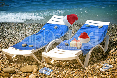 Christmas beach: deckchair and hat of Santa Claus. 3 D rendering.