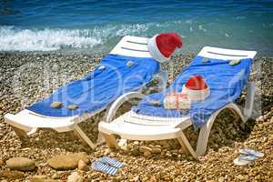 Christmas beach: deckchair and hat of Santa Claus. 3 D rendering.