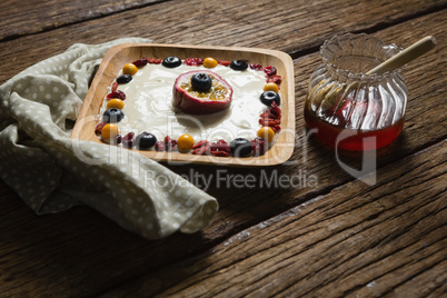 Fruit yogurt and honey on a wooden table