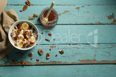 Fruit cereal and honey on a wooden table