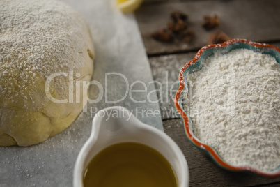 High angle view of dough and flour with cooking oil