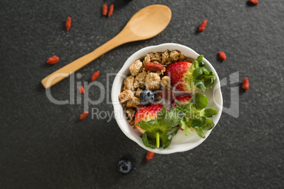 Bowl of breakfast cereals and fruits with spatula