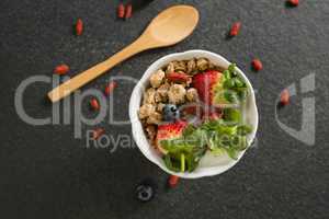 Bowl of breakfast cereals and fruits with spatula