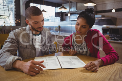 Friends reading menu in cafe