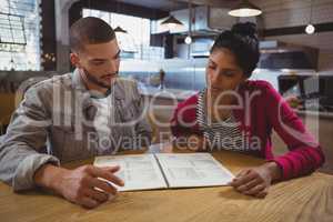 Friends reading menu in cafe