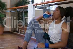 Tired male dancer drinking water at studio