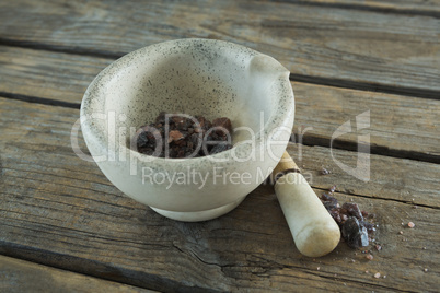 Black salt in mortar on wooden table