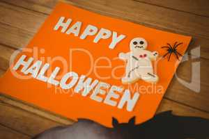 Happy Halloween text with cookies on orange paper