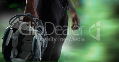 American football player holding helmet with green transition