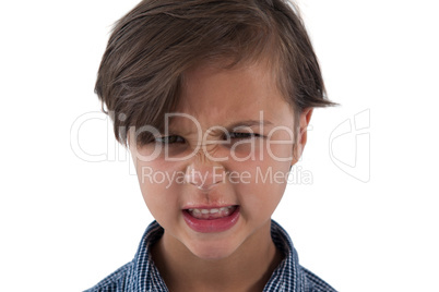 Angry boy standing against white background