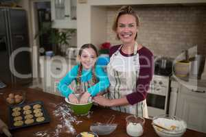 Mother and daughter preparing cookies in kitchen