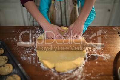 Mother and daughter preparing cookies in kitchen