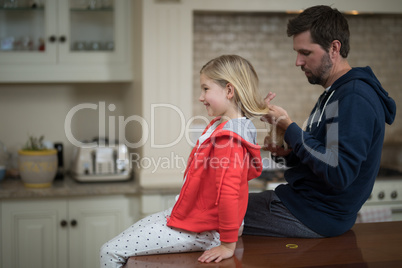 Father making daughters hairstyle