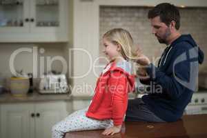 Father making daughters hairstyle