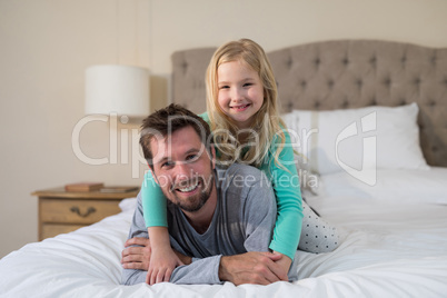 Father and daughter having fun on bed