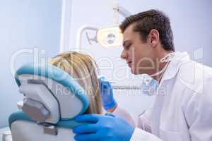 Side view of dentist polishing  woman teeth
