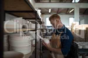Male potter checking ceramic vase