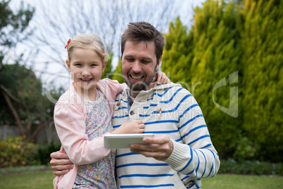 Young girl and father using digital tablet