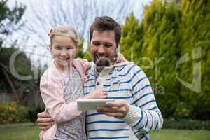 Young girl and father using digital tablet