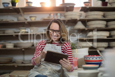 Female potter using digital tablet