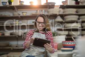 Female potter using digital tablet